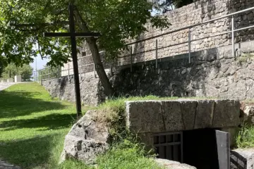 Wooden cross beside the wartime shelter on the Franciscan Martyrs tour at Široki Brijeg