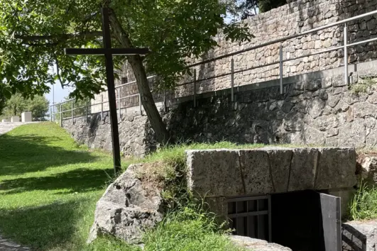 Wooden cross beside the wartime shelter on the Franciscan Martyrs tour at Široki Brijeg
