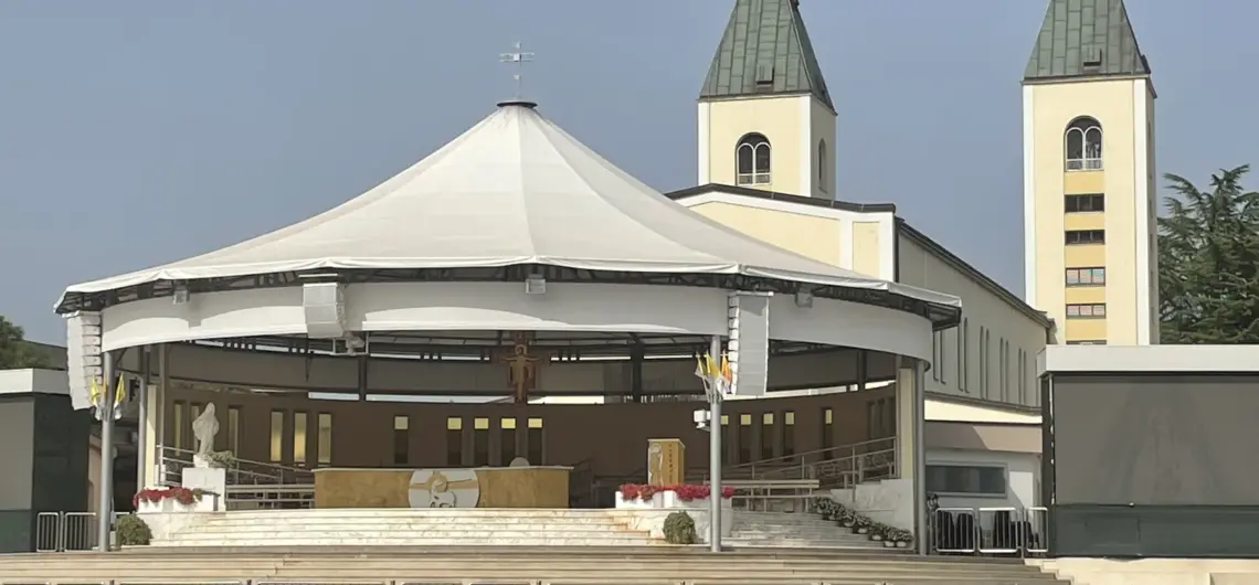 Pilgrimage Trips from Rome: Assisi, Florence or Medjugorje 1 Outdoor altar and rows of benches beneath the twin towers of St James’s Church in Medjugorje