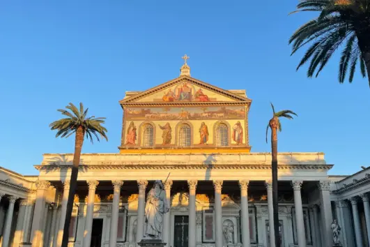 Sunlit facade and courtyard of St Paul Outside the Walls, Rome